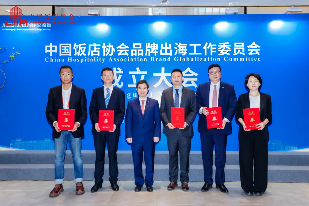 中国饭店协会会长陈新华(中左)与工作委员会主任委员中国饭店协会副会长兼秘书长宋小溪(右一),副主任委员:郎富平 浙江旅游职业学院党委委员、副校长(左二)、赵亨 南京大惠企业发展有限公司董事长(左一)、阙嘉华 广东嘉豪食品有限公司CEO(中右)、唐鸣 北京诺金国际酒店管理有限责任公司总经理(右二)合影.webp.png